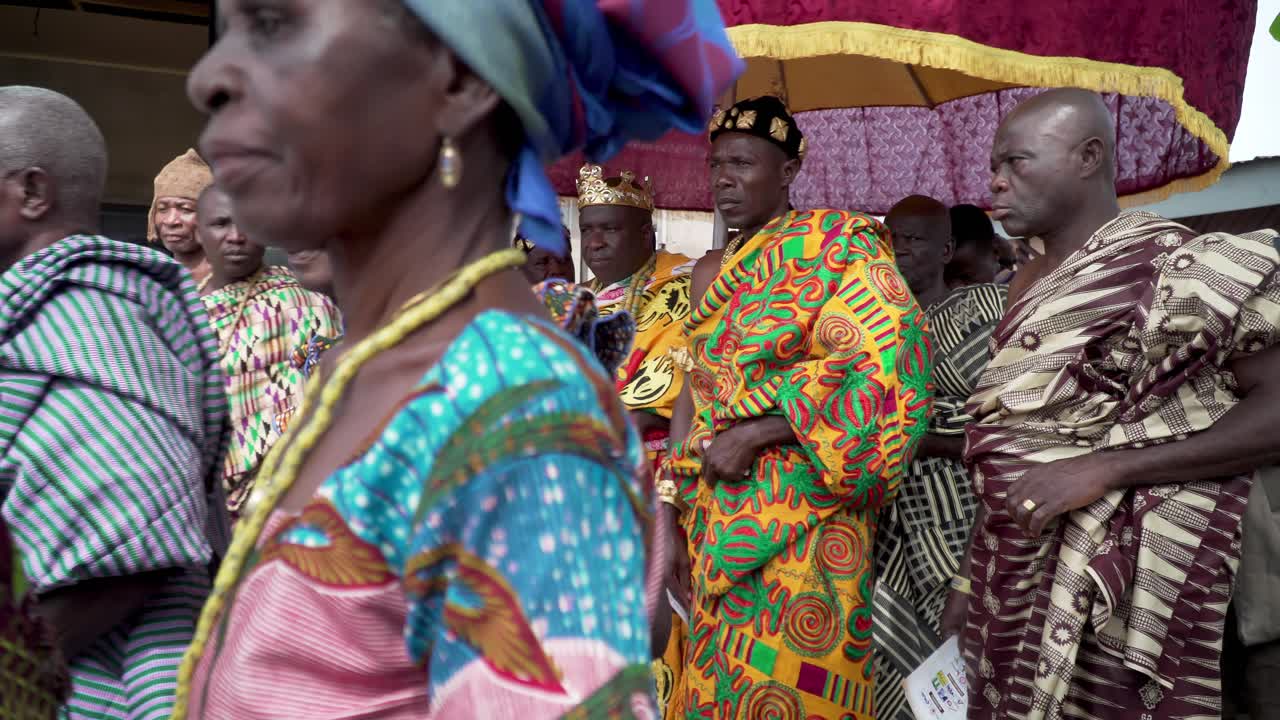 A paramount chief and king march with his entourage under the royal umbrella in a festival procession in Ghana, West Africa.