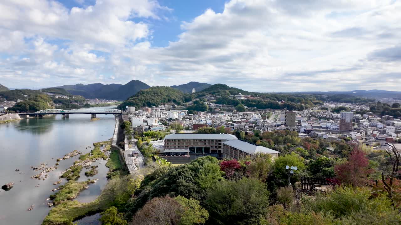이누야마 성 (inyama castle) 은 일본의 구름이 가득한 하늘 아래 키소 강, 다리, 그리고 도시 풍경을 장엄하게 내려다보고 있습니다.