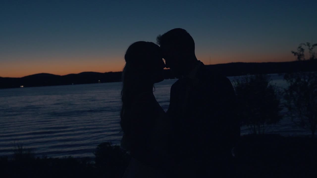 뉴햄프셔의 화이트 산맥에 있는 위니페소키 호수 앞에서 패닝하는 낭만적인 일몰 실루엣