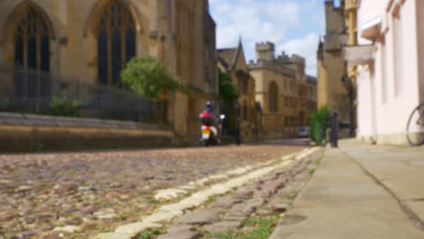 tiro desenfocado de scooter y peatones caminando por la calle old oxford