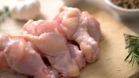 fresh raw chicken wings on wooden board with ingredients