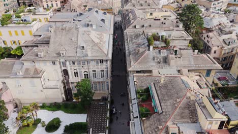 genoa's historic center with ancient buildings and tourists walking down narrow streets, aerial view