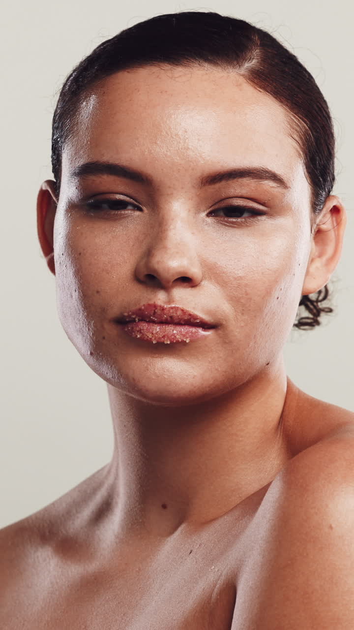 Joven aplicándose suavemente exfoliante labial en los labios