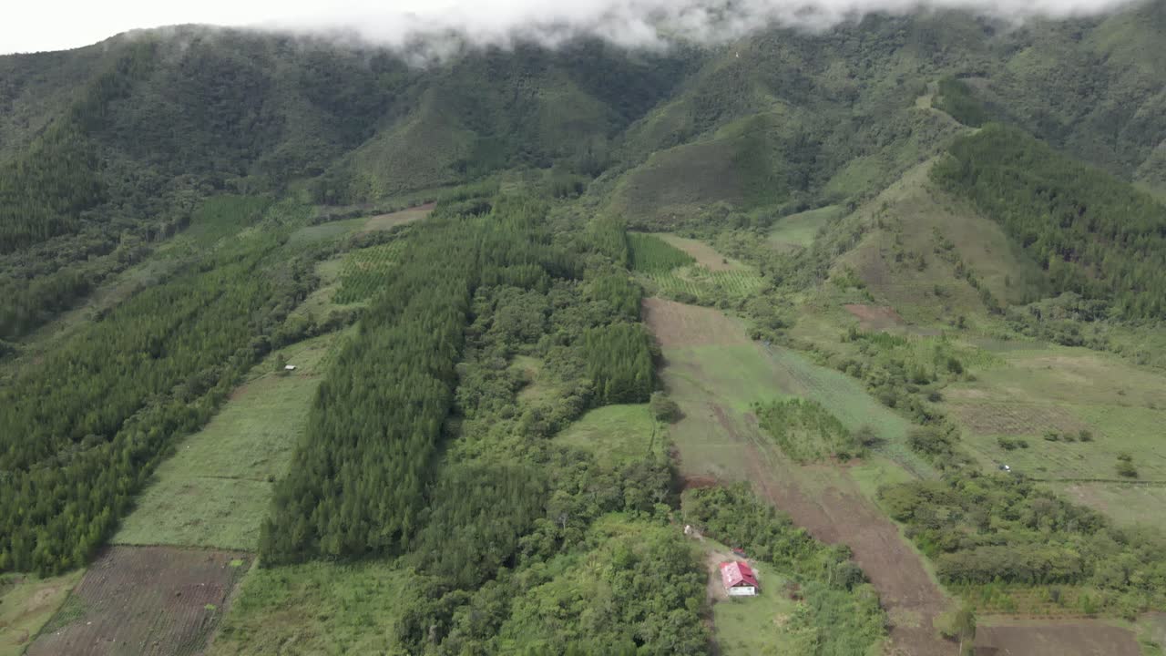 inclinación aérea hasta las montañas tropicales cubiertas de nubes desde el fondo del valle