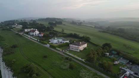 Panning-aerial-reveal-large-houses-on-cliff-top-Kingsdown-kent-UK-misty-dawn-morning