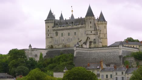 hilltop château with surrounding buildings and houses in saumur france with dymanic cloudscape 4k