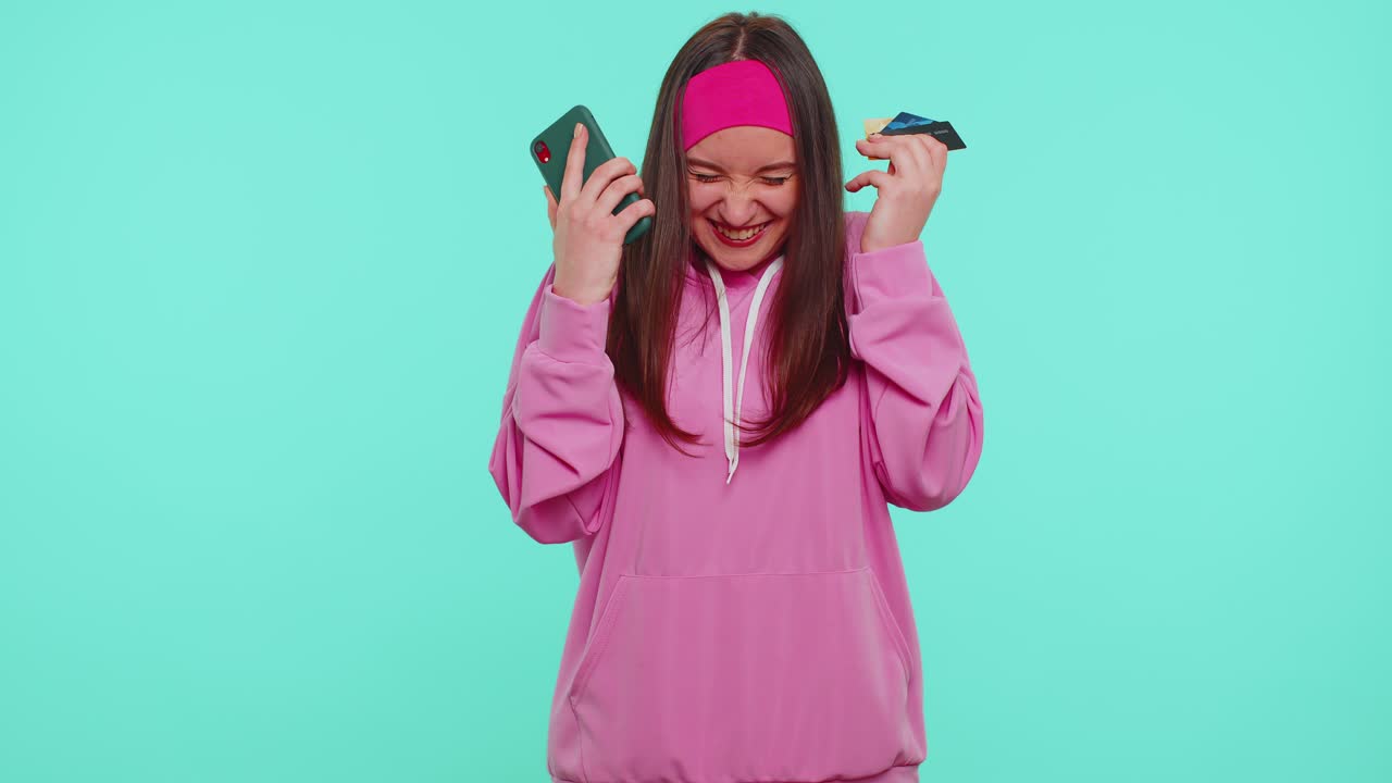 la chica usa teléfono celular móvil y tarjeta de crédito de plástico navegación bancaria decir wow sí descubrió gran gran victoria