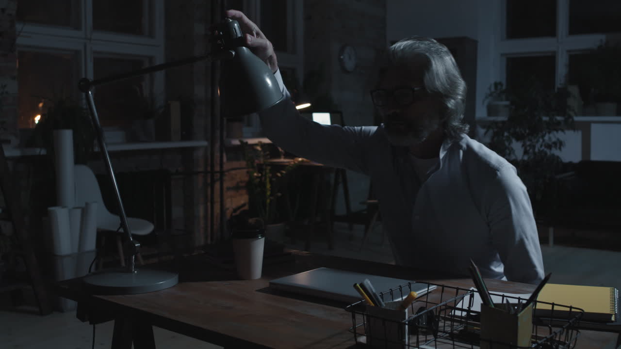 Un uomo che lavora fino a tardi in un ufficio poco illuminato