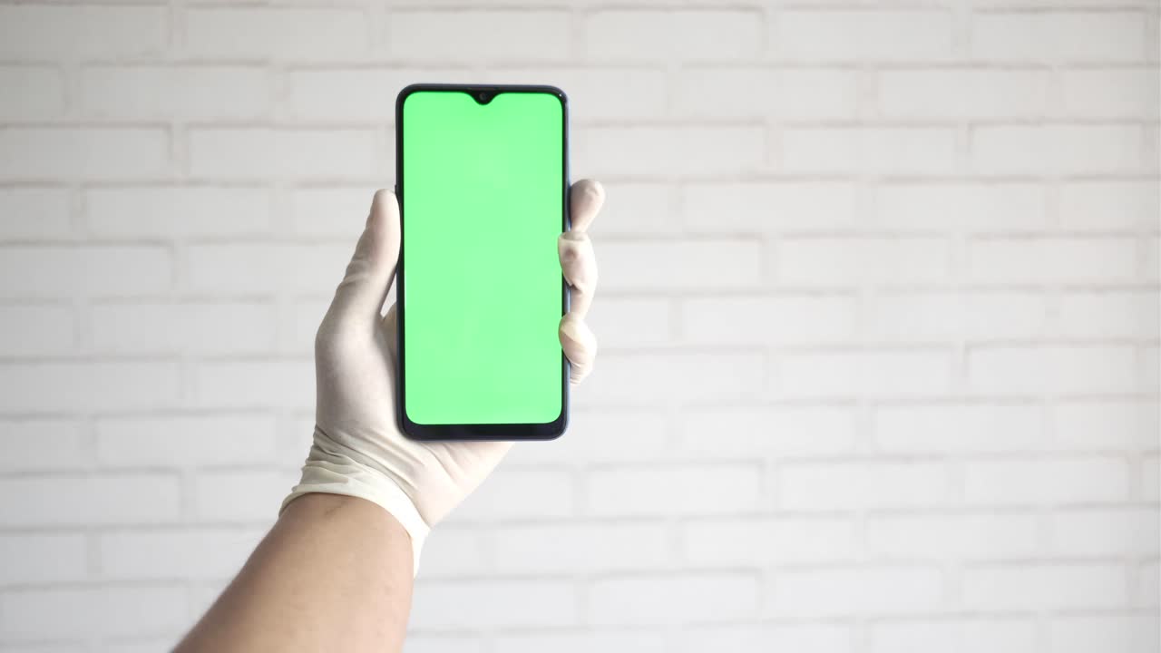 teléfono inteligente en la mano con pantalla verde