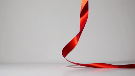 elegant red ribbon curving on a minimalist background