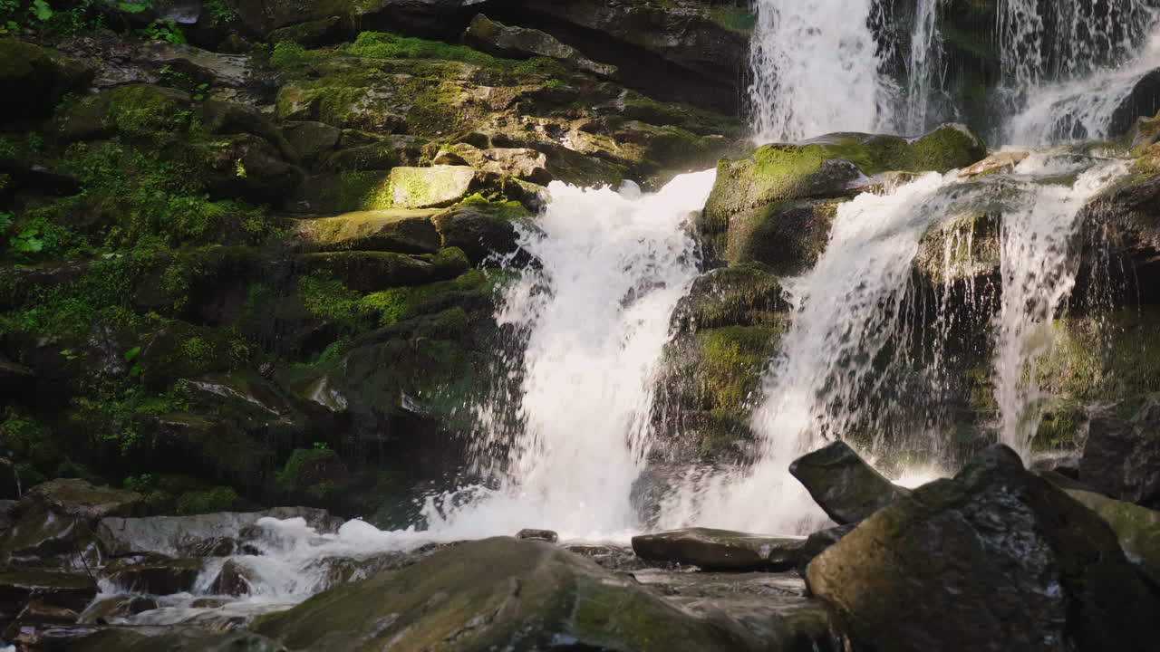 Una splendida cascata in montagna. Acqua che scorre sulle rocce.