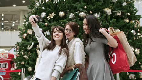 women taking selfie over christmas tree