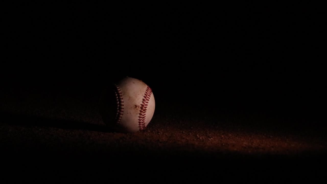 Splendida palla da baseball che rotola nella terra di notte.