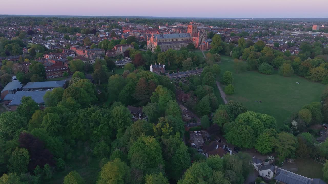 A cinematic drone flies over St Albans Park, starting top-down and tilting up to reveal the picturesque landscape, lake, and surrounding scenery in a breathtaking view