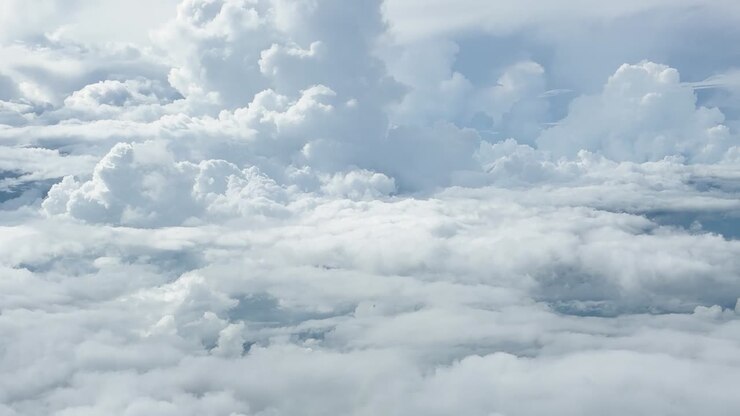 Cinematic flight through dense white cloud formations under a bright and clear blue sky