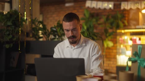 man working on laptop in a festive office