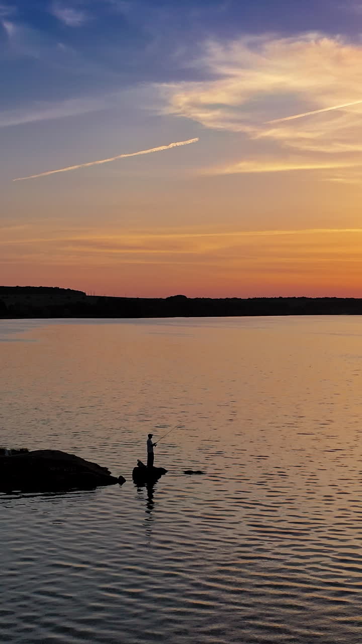 Beautiful sunset is reflecting in the river. Sunset lake landscape. Colorful sky. Vertical video