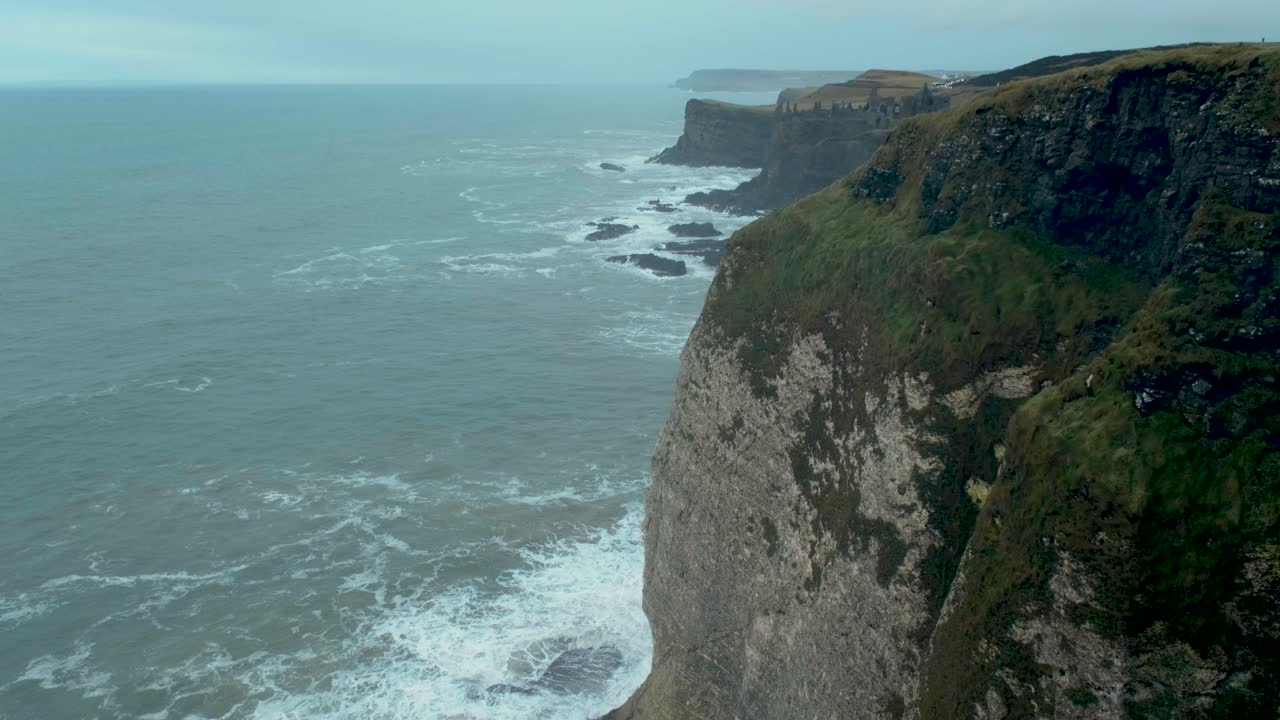 Waves roll onto the Irish shore under a soft, overcast winter light