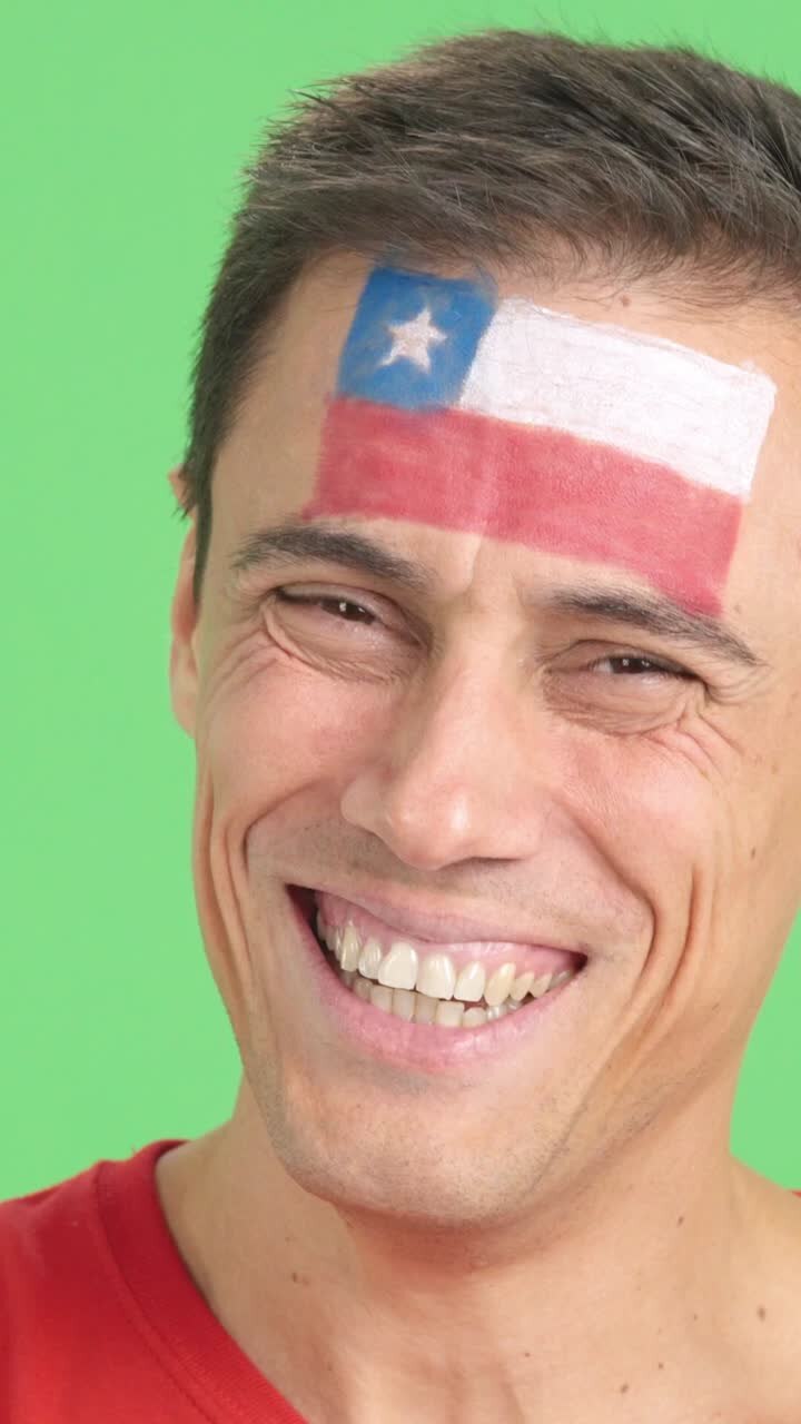 Man with a chilean flag painted on the face smiling