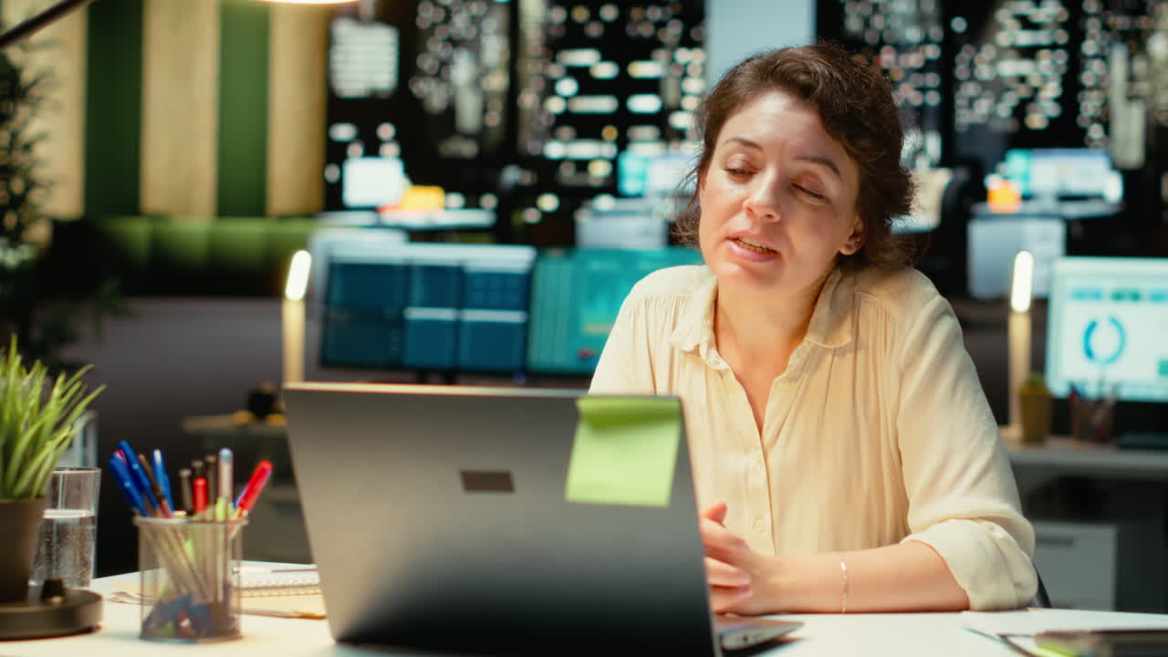 Vertical Video Professional woman sits in front of laptop during a teleconference