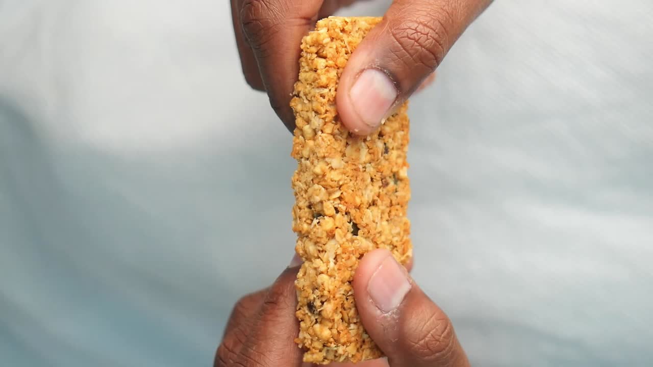 Breaking a granola bar in half