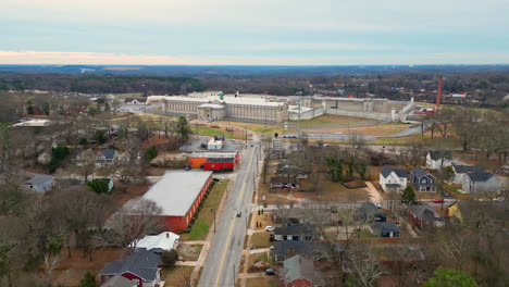 aerial wide shot showing leafless trees and united states penitentiary prison in atlanta city