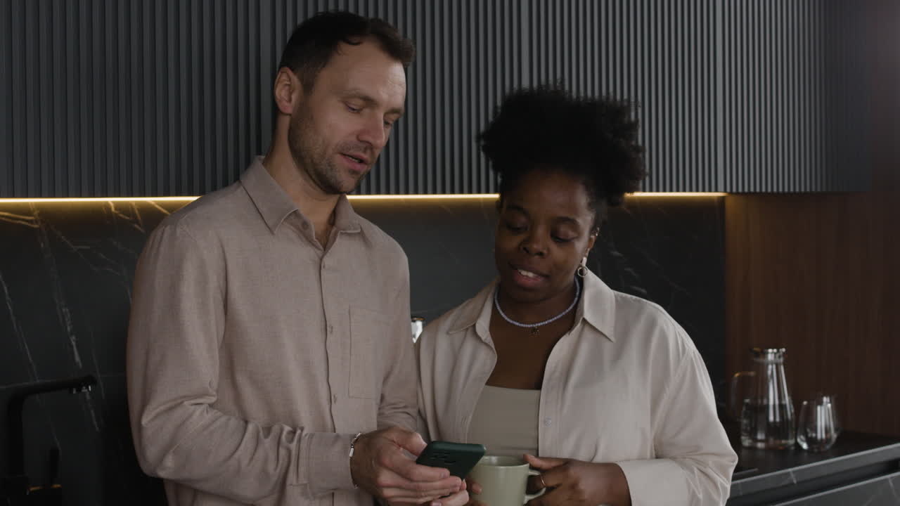 Couple looking at phone in kitchen