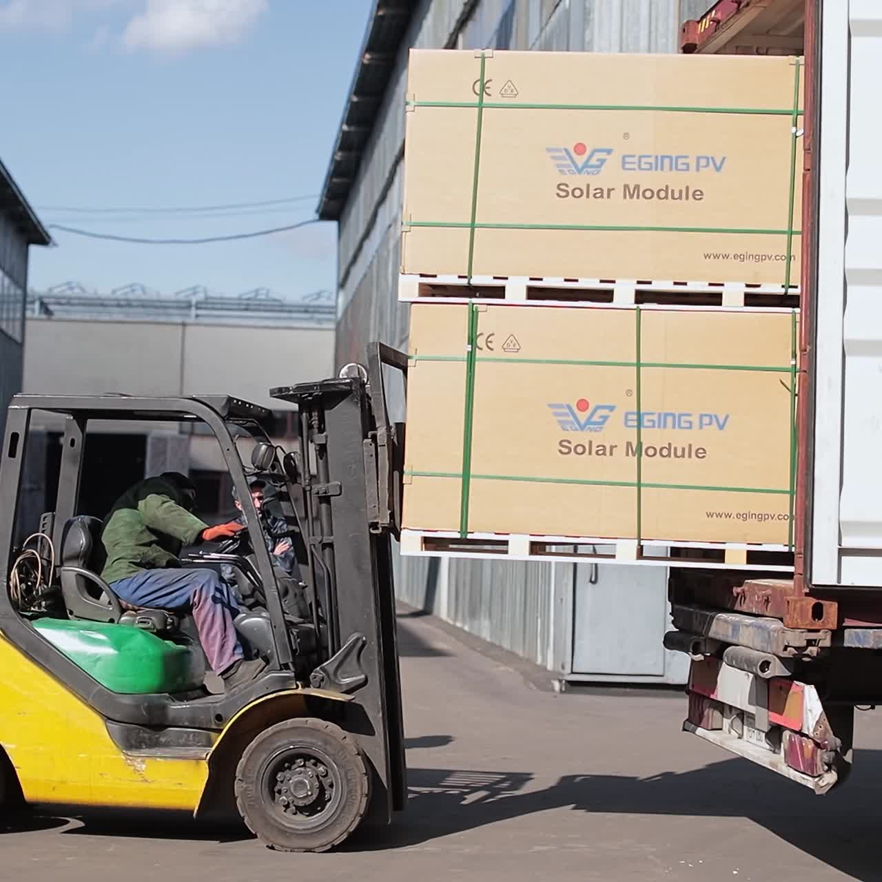 Transportation boxes of goods from truck. Worker riding outdoor forklift moving pallets of cardboards