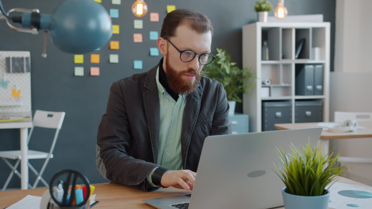 hombre trabajando en una computadora portátil en una oficina moderna