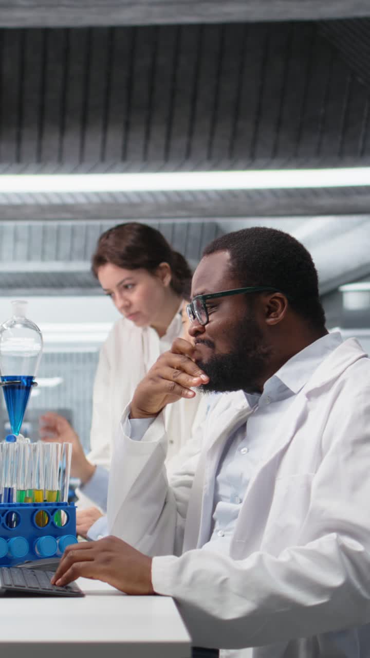Vertical video Confused laboratory scientist frowning while looking at DNA patient data