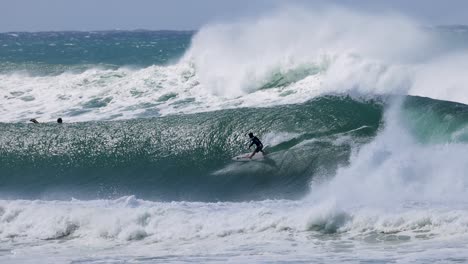 surfer riding massive waves during cyclone alfred at kirra beach