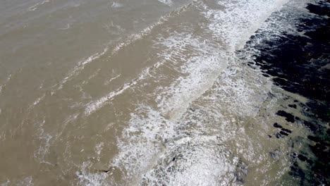 4k drone video of small waves hitting the base of the white cliffs near dover