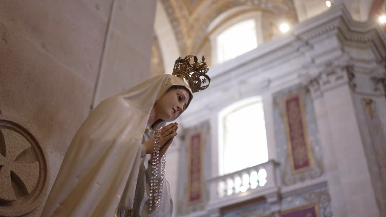 Virgin Mary statue of Our Lady of Fatima wearing a golden crown and holding rosary beads