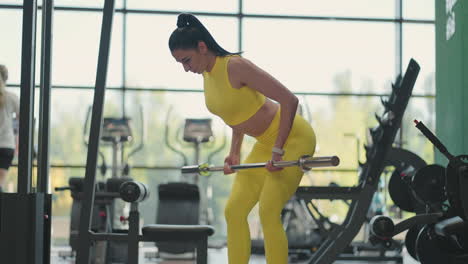 Mujer-Hispana-Realizando-Barra-Inclinada-Sobre-Fila.-Mujer-Fitness-Entrenando-Fila-Inclinada-También-Conocida-Como-Fila-Inclinada-También-Conocida-Como-Fila-Con-Barra.-Entrena-Los-Músculos-De-La-Espalda-Con-Una-Barra-Mientras-Estás-De-Pie-Inclinado