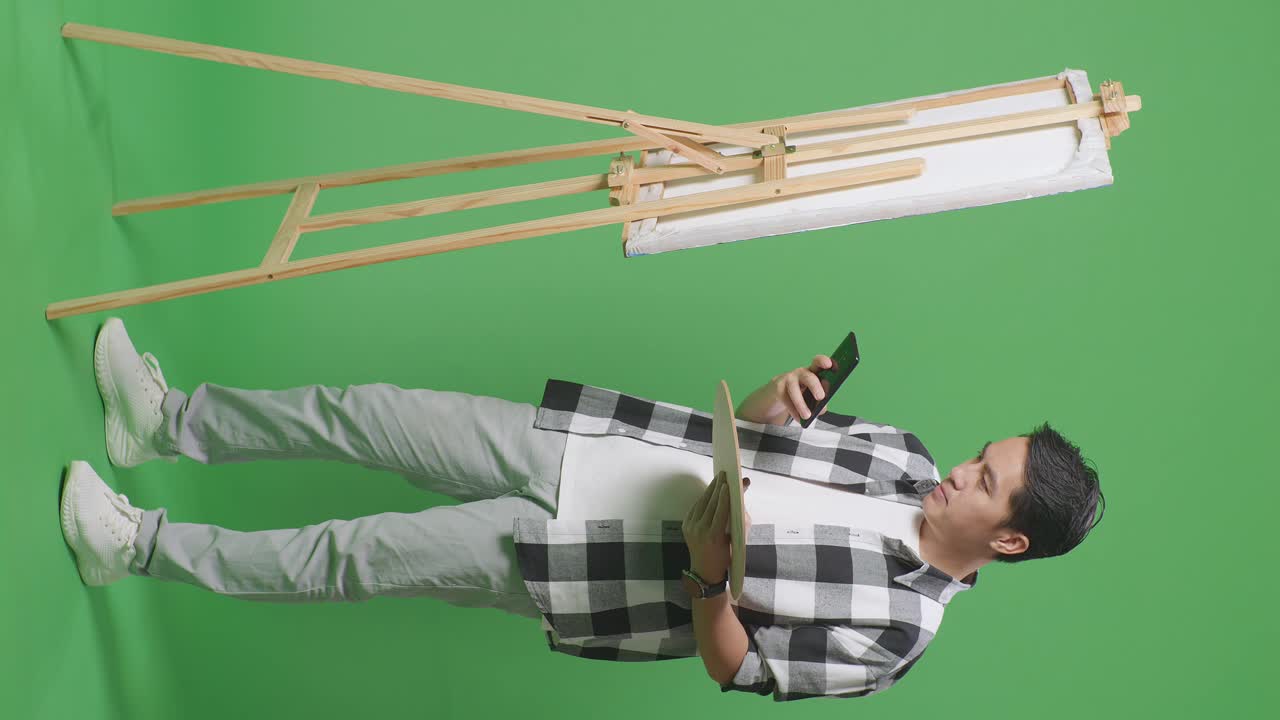 그림을 사진으로 찍기 위해 전화를 사용하는 예술가