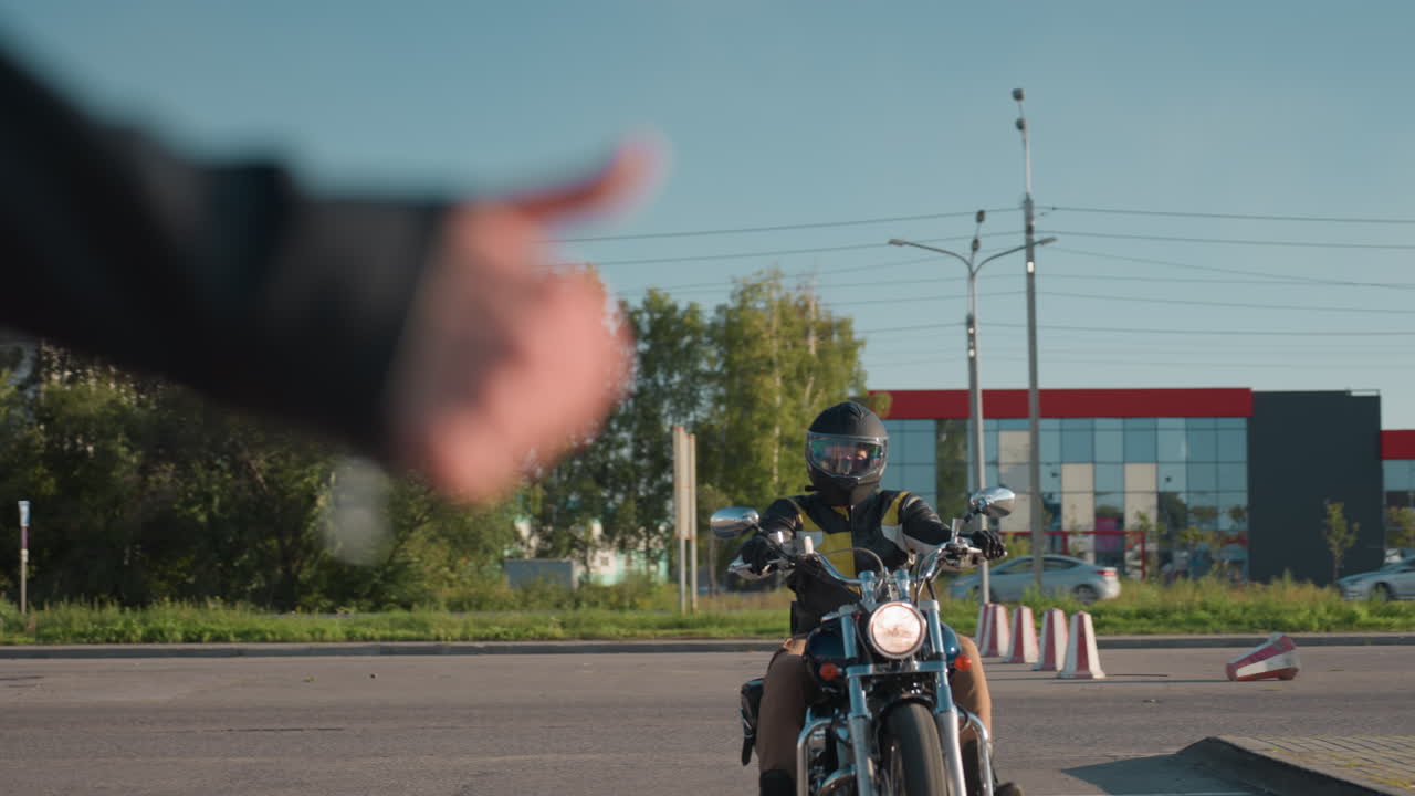 Motorcycle rider wearing helmet and leather jacket stops on city street as passenger looks around, with chrome details and modern background reflecting lifestyle of urban travel