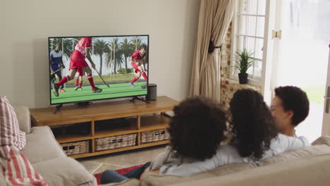 composite of happy family sitting at home together watching hockey match on tv