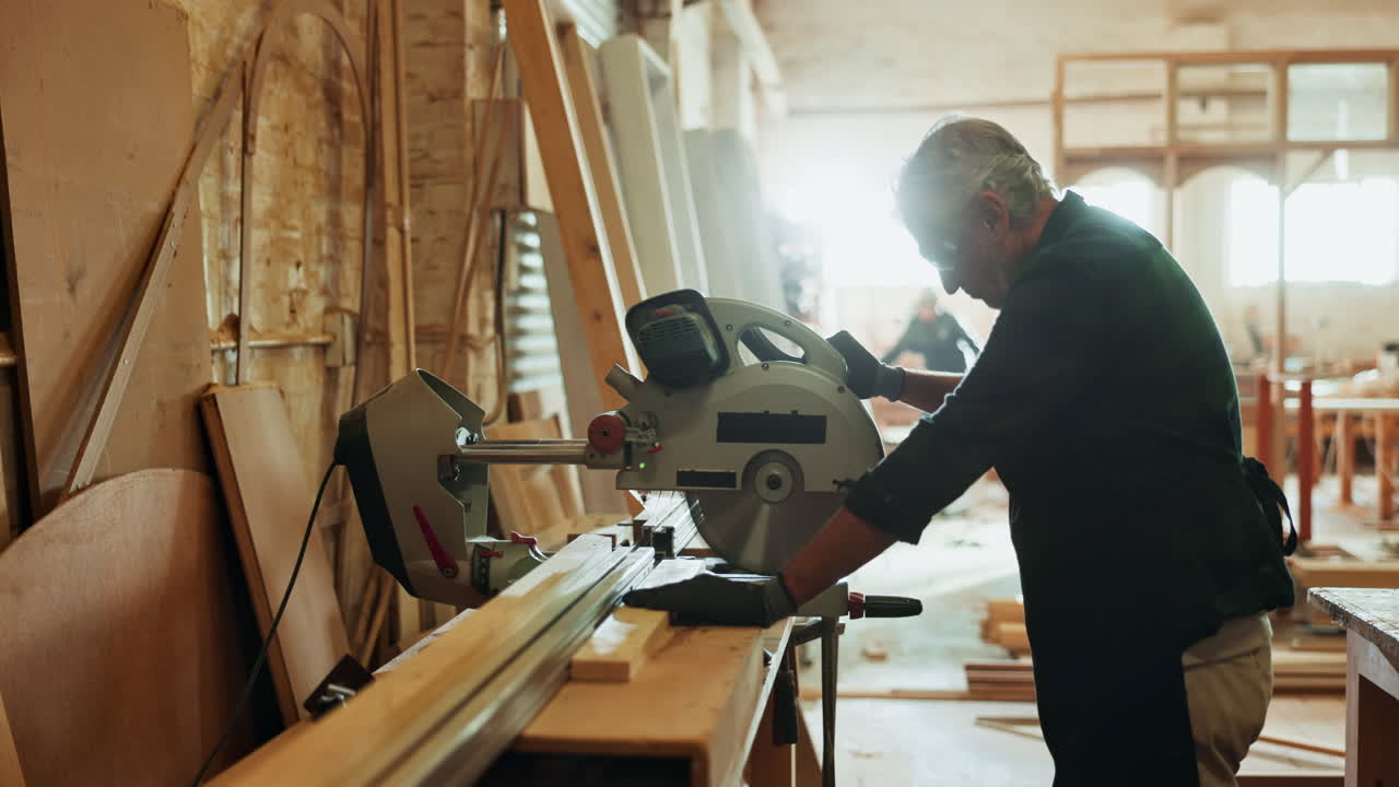 A man working with a saw in a carpentry workshop