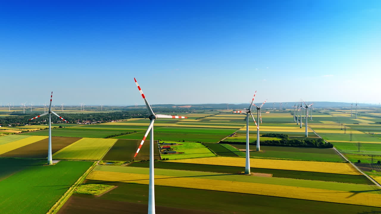 Beautiful green fields with multiple wind mills. Clean energy concept. Aerial view.