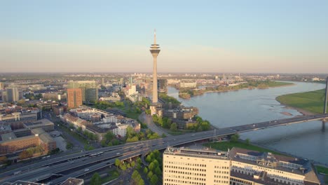 rhine tower and morning traffic crossing rhine bridge in dusseldorf, drone aerial shot