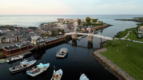 Aerial-orbiting-footage-of-Perkins-Cove-drawbridge-in-Ogunquit,-Maine-at-sunset