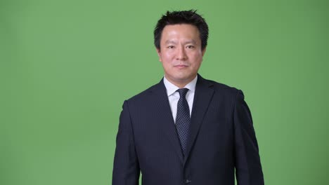 녹색 배경에 성숙한 일본 사업가