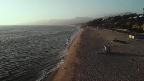 Eine-Luftaufnahme-über-Dem-Strand-In-Malibu-In-Kalifornien-In-Der-Nähe-Der-Point-Dume-Klippen-Am-Abend,-Wenn-Die-Sonne-Untergeht