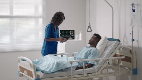 an african-american female doctor comes to the patient and asks about his condition and conducts an examination. diagnosis of symptoms after treatment