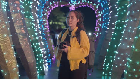 female photographer admiring beautiful multicolored lights at night at the park