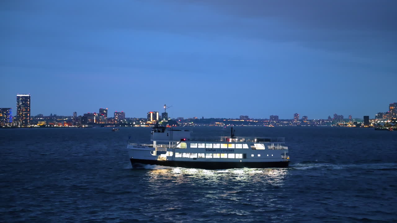 New York, USA, 1. august 2025: Båt opplyst på Hudson River med bylys. Liten passasjerbåt lyser om natten på Hudson River