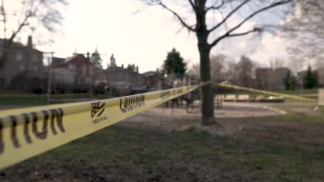 yellow caution tape surrounds a local playground that is closed due to covid-19