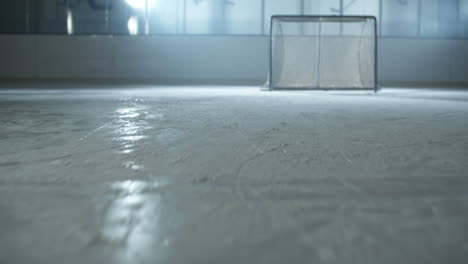 close up of a puck being struck by hockey player on the ice arena