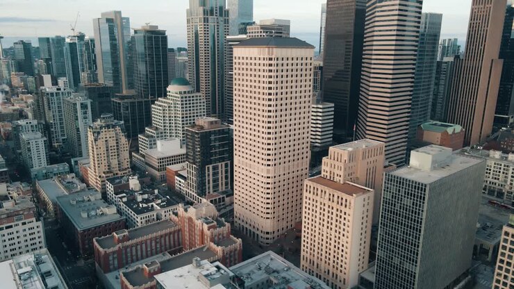 Paralaxe orbital aérea em torno dos edifícios bege e modernos de prata elegante do horizonte do centro de Seattle, Washington