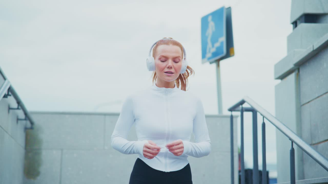 Woman jogging on stairs with headphones